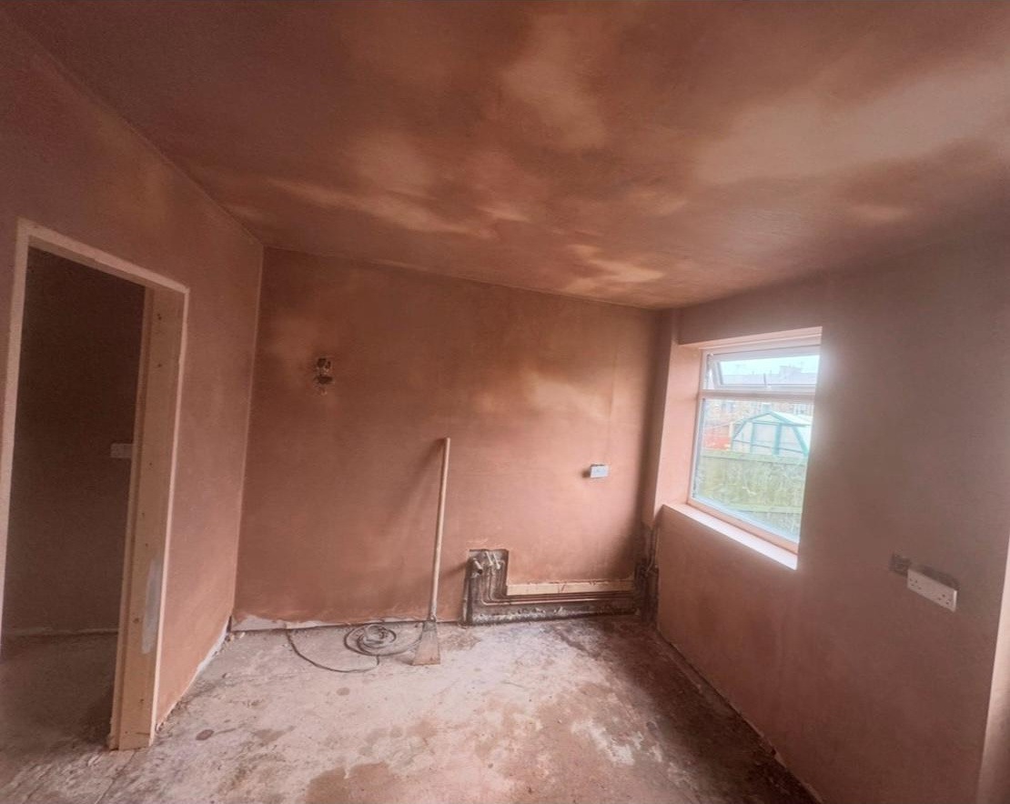 Reception room walls and ceiling freshly bonded and skimmed in pink plaster by MCB, smooth even finish ready for decoration