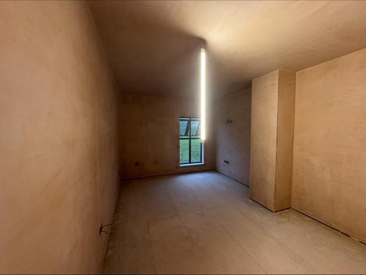 Hallway walls and ceiling fully skimmed in fresh plaster, sharp internal corners and crisp window reveal